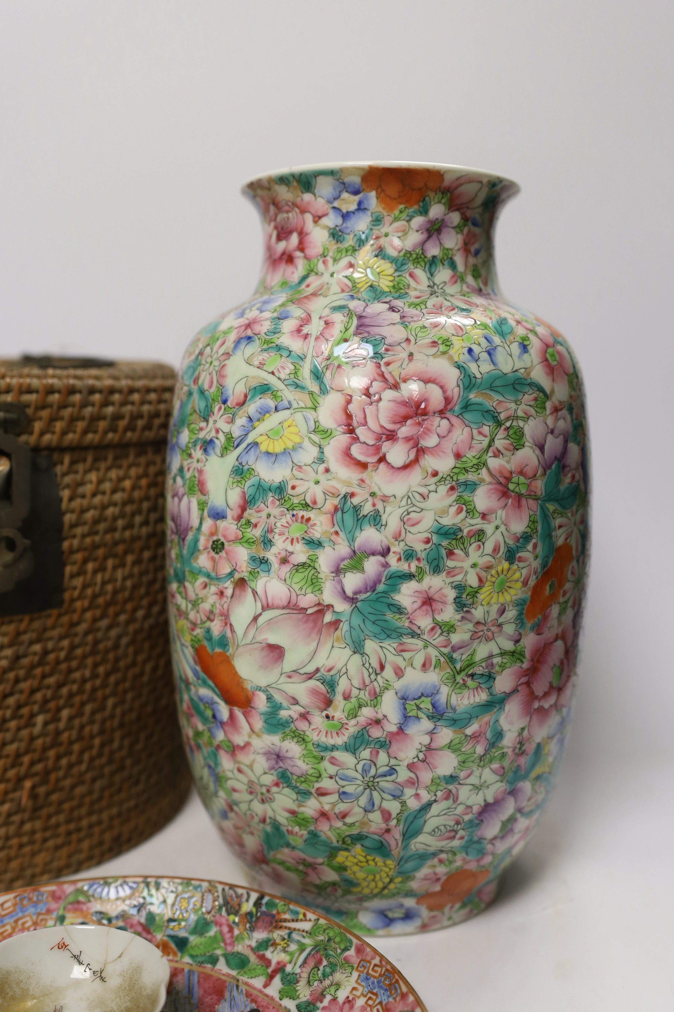 Two Chinese enamelled porcelain Millefleur vases, one with Qianlong Mark, both late 19th/early 20th century, together with two Chinese famille rose dishes and a similar basket cased tea kettle